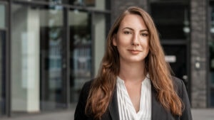 Frau in Business-Kleidung vor Bürogebäude