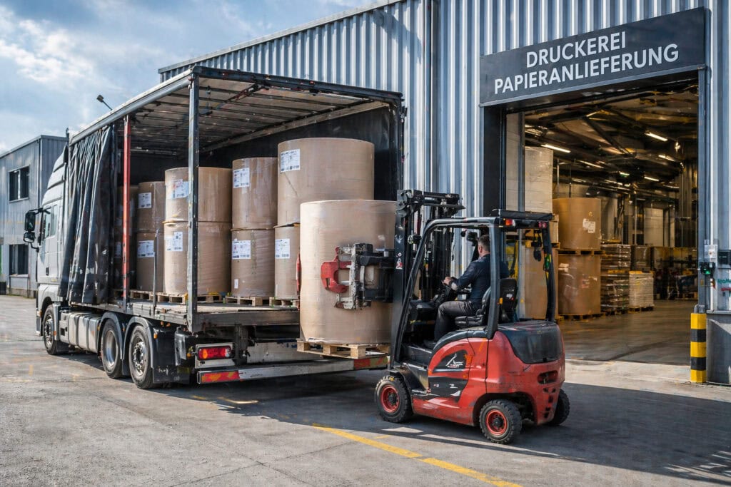 Gabelstapler entlädt Papierrollen vor Druckerei