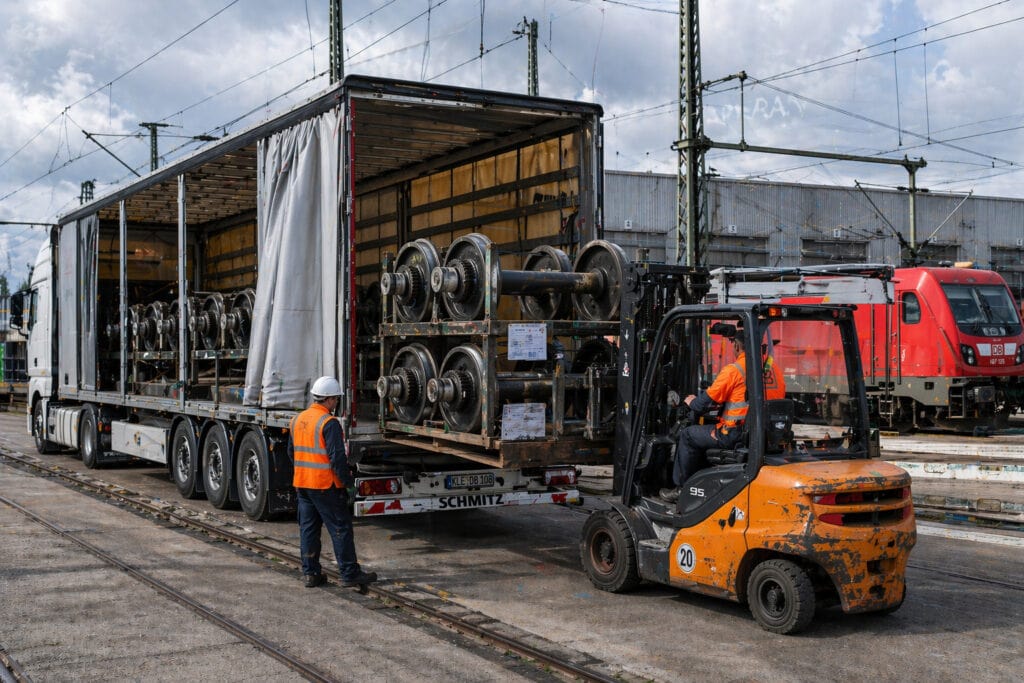 Gabelstapler entlädt Eisenbahnradsätze von Lastwagen